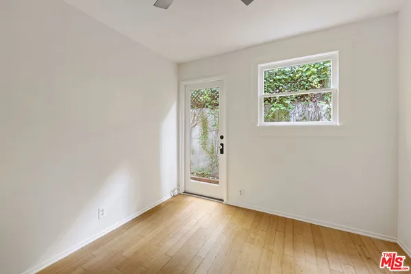 an empty room with wooden floor and window