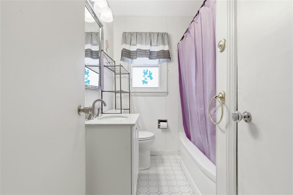513 Lombard Street Irwin, PA 15642 - Photo 16 of 31 a bathroom with a sink a toilet and shower curtain