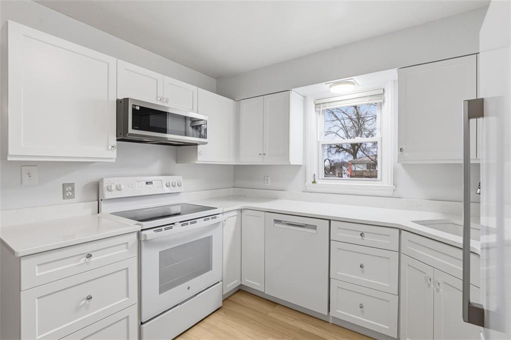 513 Lombard Street Irwin, PA 15642 - Photo 2 of 31 a kitchen with white cabinets and white appliances