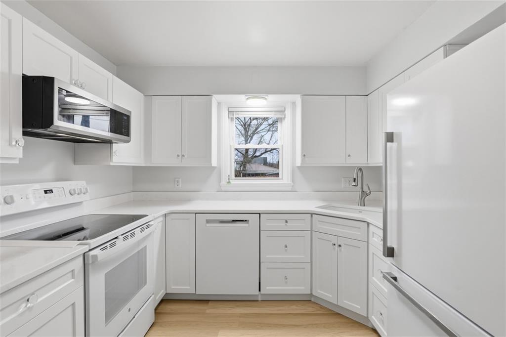 513 Lombard Street Irwin, PA 15642 - Photo 3 of 31 a kitchen with white cabinets and white appliances