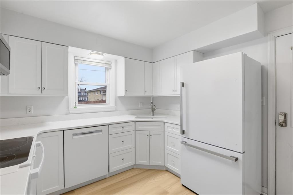 513 Lombard Street Irwin, PA 15642 - Photo 4 of 31 a kitchen with white cabinets and white appliances
