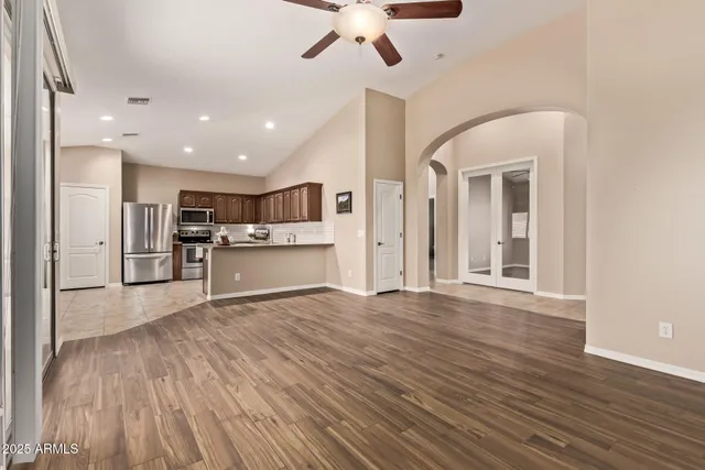 a view of a livingroom with wooden floor and a ceiling fan