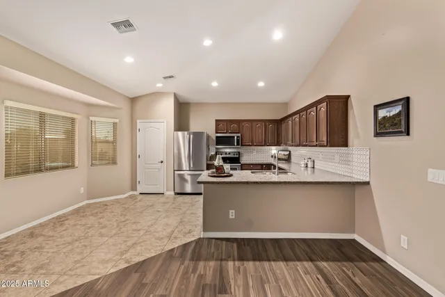 a kitchen with stainless steel appliances granite countertop a sink stove and refrigerator