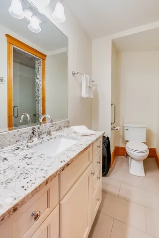 a spacious bedroom with a bed a large window table and chairs