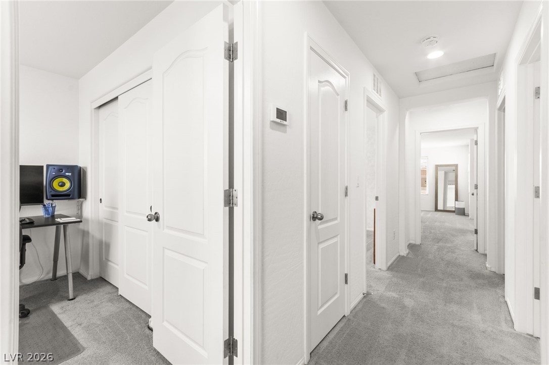 6435 Point Isabel Way Las Vegas, NV 89122 - Photo 24 of 57 A well-lit corridor provides access to several rooms, creating a comfortable flow within the residence.