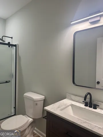 a bathroom with a sink a toilet and mirror