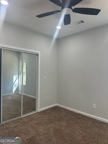 an empty room with sliding door and wooden floor