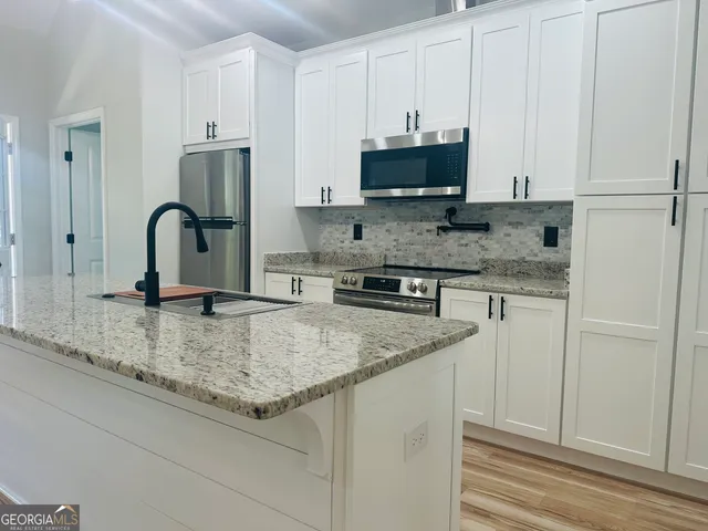 a view of a kitchen counter space a sink and cabinets