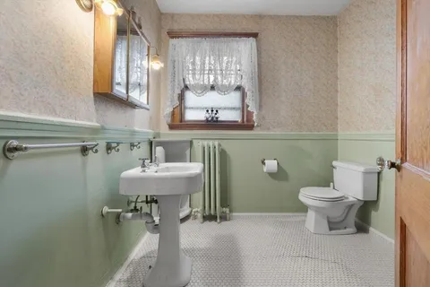 a bathroom with a sink a toilet and a mirror