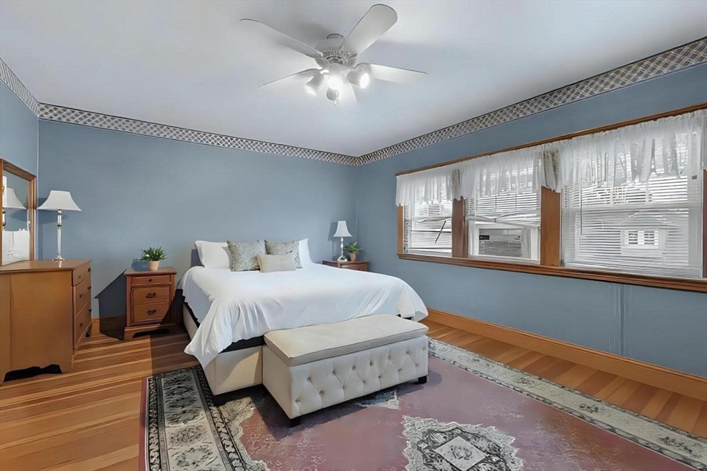 65-67 Halifax Street Boston, MA 02130 - Photo 18 of 21 a spacious bedroom with a bed a dresser and wooden floor