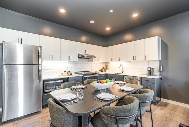 50 Music Square West, Unit 114 Nashville, TN 37203 - Photo 23 of 83 a kitchen with stainless steel appliances kitchen island granite countertop a dining table and chairs