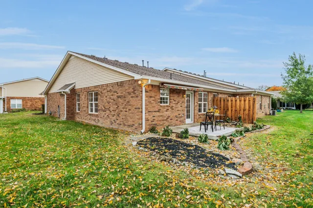 a backyard of a house with table and chairs