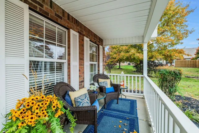 a balcony with wooden floor and outdoor seating