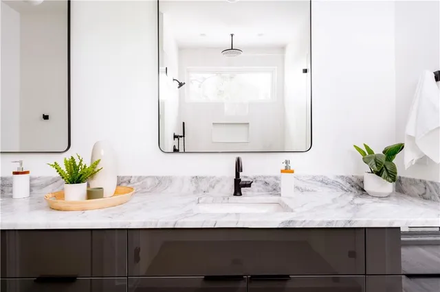 a bathroom with a granite countertop sink and a mirror