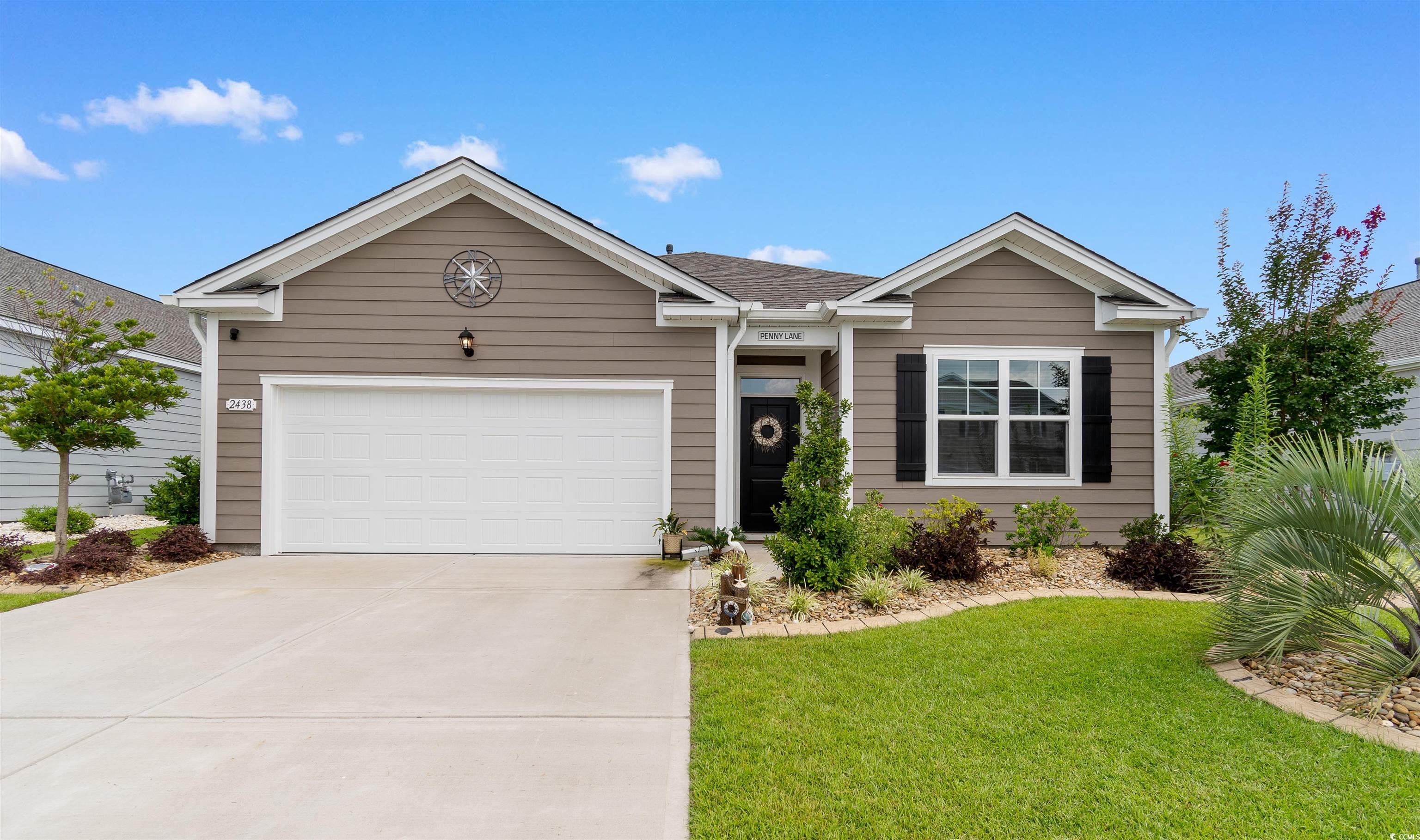Ranch-style home featuring an attached garage, concrete driveway, and a front lawn