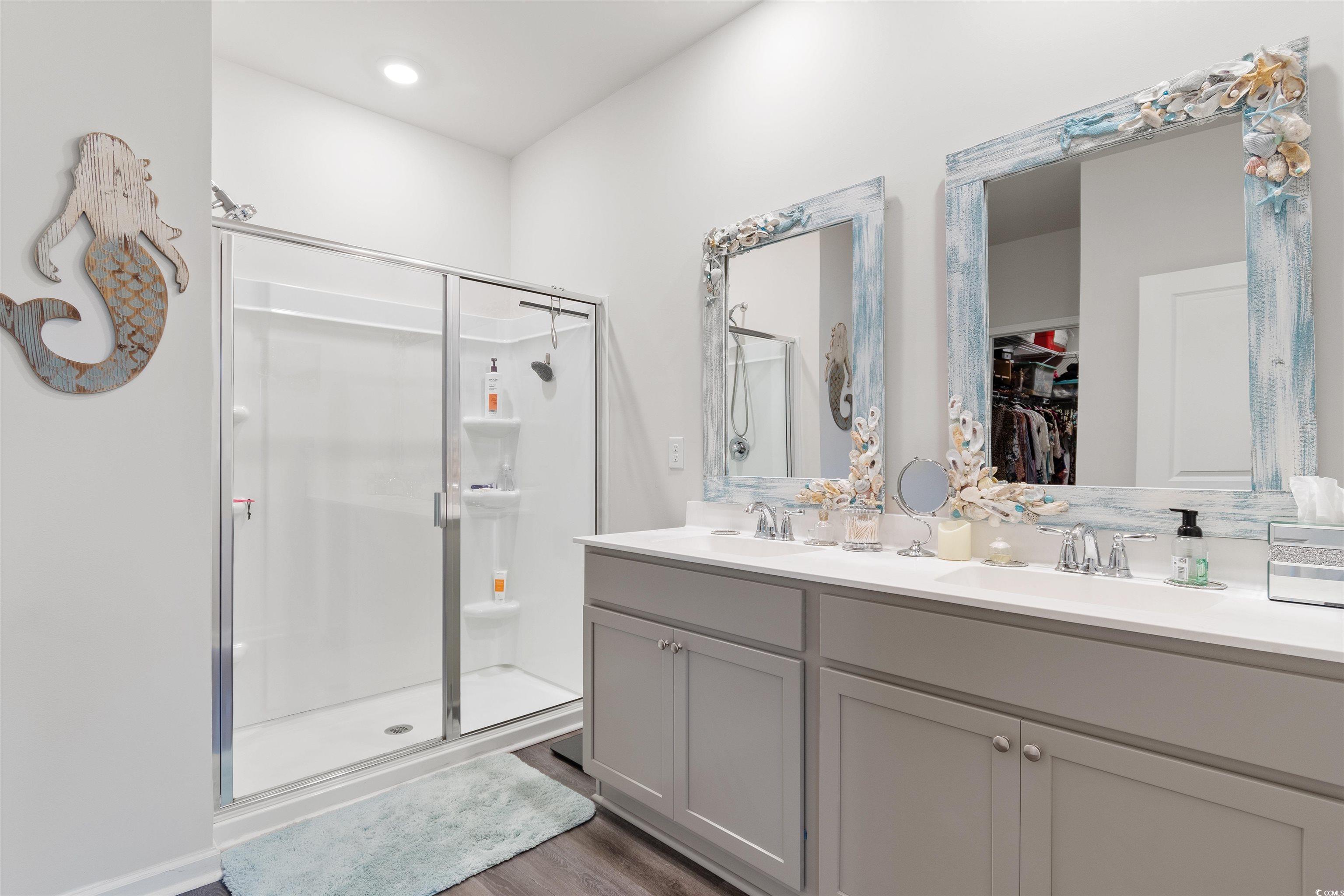 2438 Polaris Path Myrtle Beach, SC 29577 - Photo 16 of 40 Bathroom featuring a shower stall, double vanity, a walk in closet, and wood finished floors