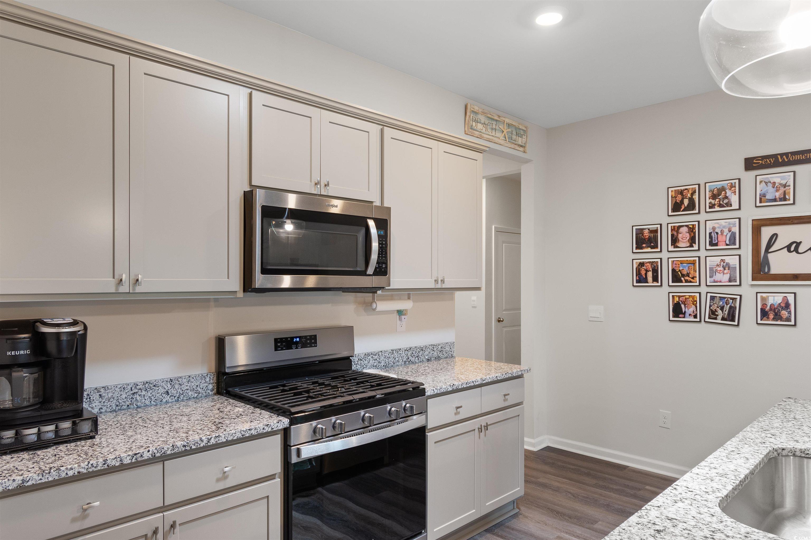 2438 Polaris Path Myrtle Beach, SC 29577 - Photo 6 of 40 Kitchen featuring appliances with stainless steel finishes, dark wood-type flooring, and light stone counters