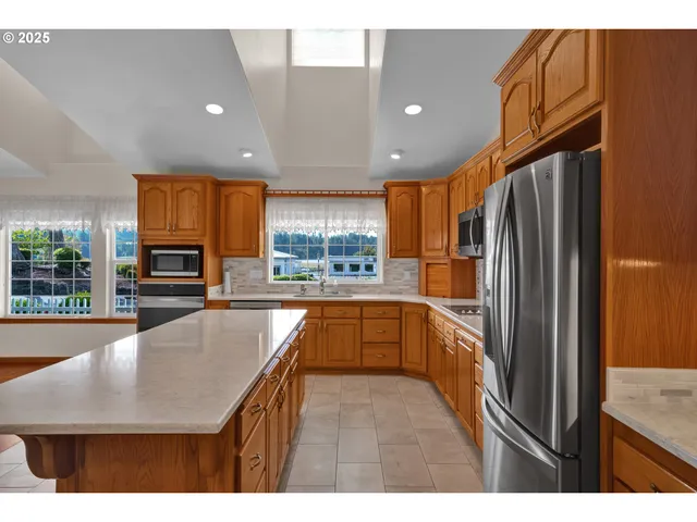 a large kitchen with stainless steel appliances granite countertop a granite counter tops and a view of living room
