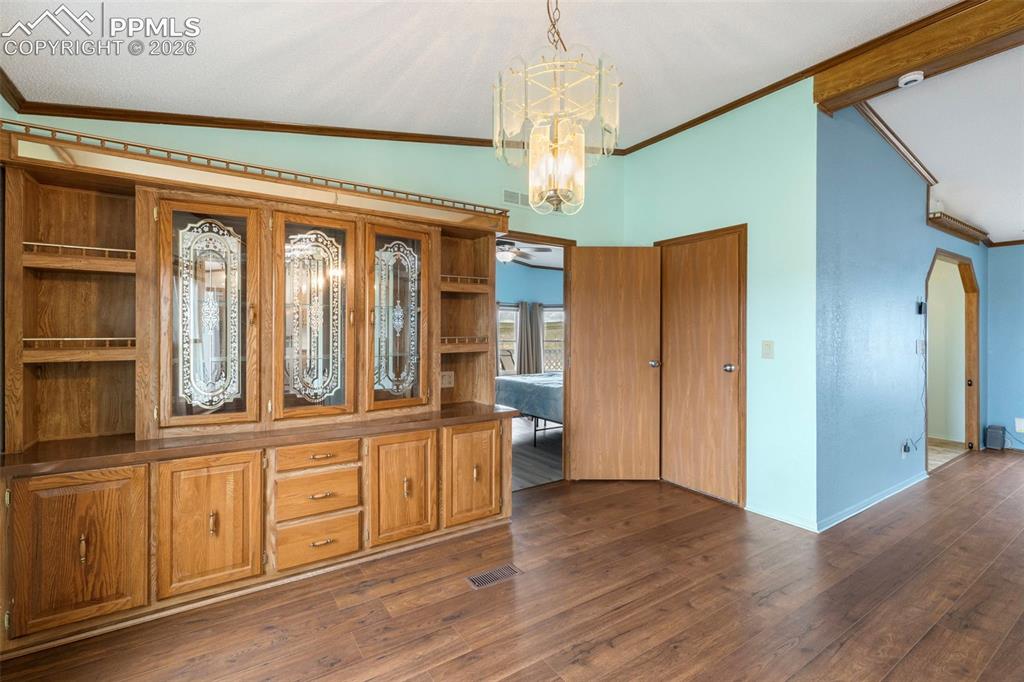 13335 Gymkhana Road Peyton, CO 80831 - Photo 15 of 38 Built-in wood-finish cabinetry featuring decorative glass door inserts and open shelving