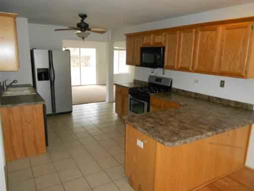 14 Highview Avenue Addison, IL 60101 - Photo 6 of 13 a kitchen with stainless steel appliances granite countertop a sink a stove top oven a chimney and a refrigerator