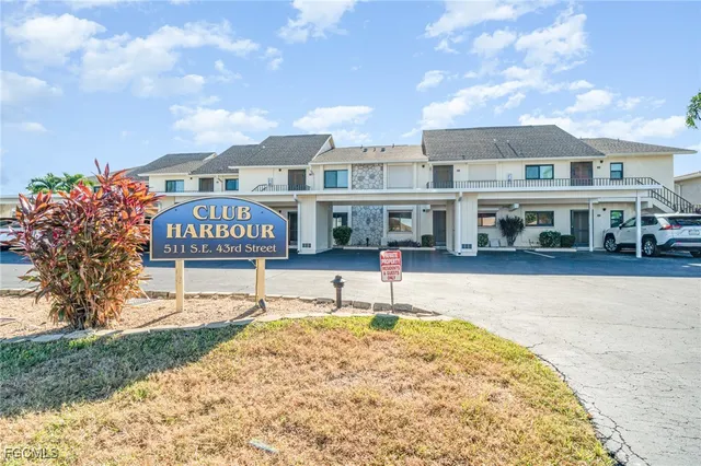 a sign on a small yard in front of a house