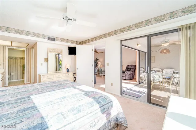 a spacious bedroom with a large bed and a chandelier