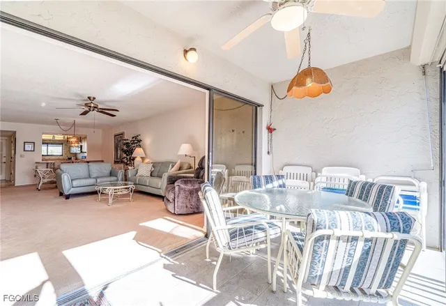a view of a dining room with furniture and a chandelier fan
