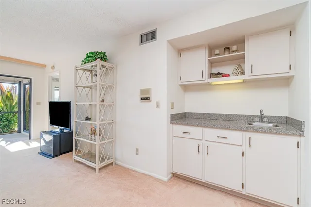 a kitchen with granite countertop a sink cabinets and stainless steel appliances
