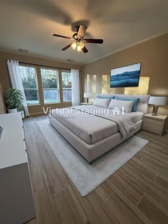 a spacious bedroom with a large bed a chandelier and windows
