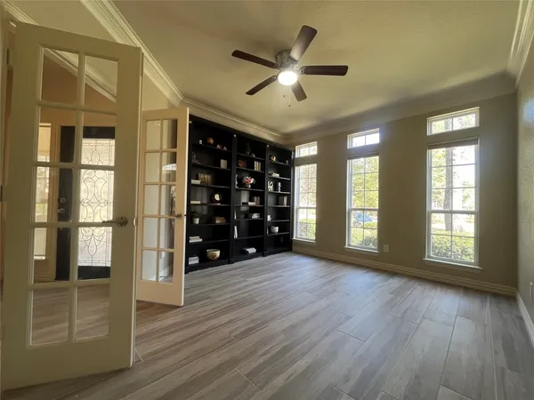a view of an empty room with a window and wooden floor