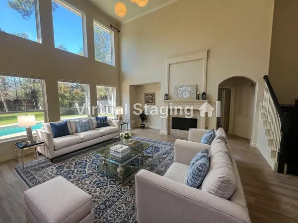a living room with furniture a fireplace and a large window