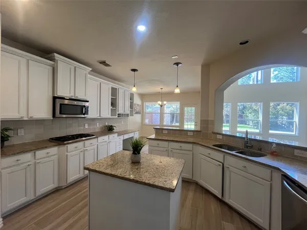 a kitchen with granite countertop a sink and white cabinets
