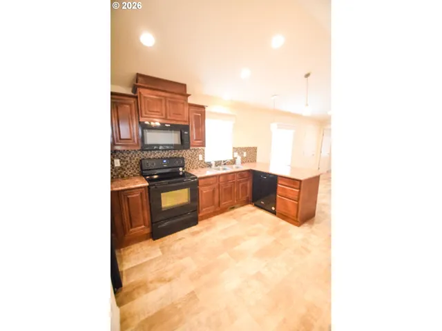 a kitchen with granite countertop a stove and a microwave