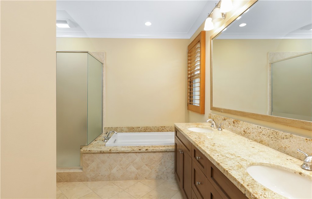 220 Kempton Irvine, CA 92620 - Photo 33 of 42 a bathroom with a granite countertop sink a mirror and a bathtub