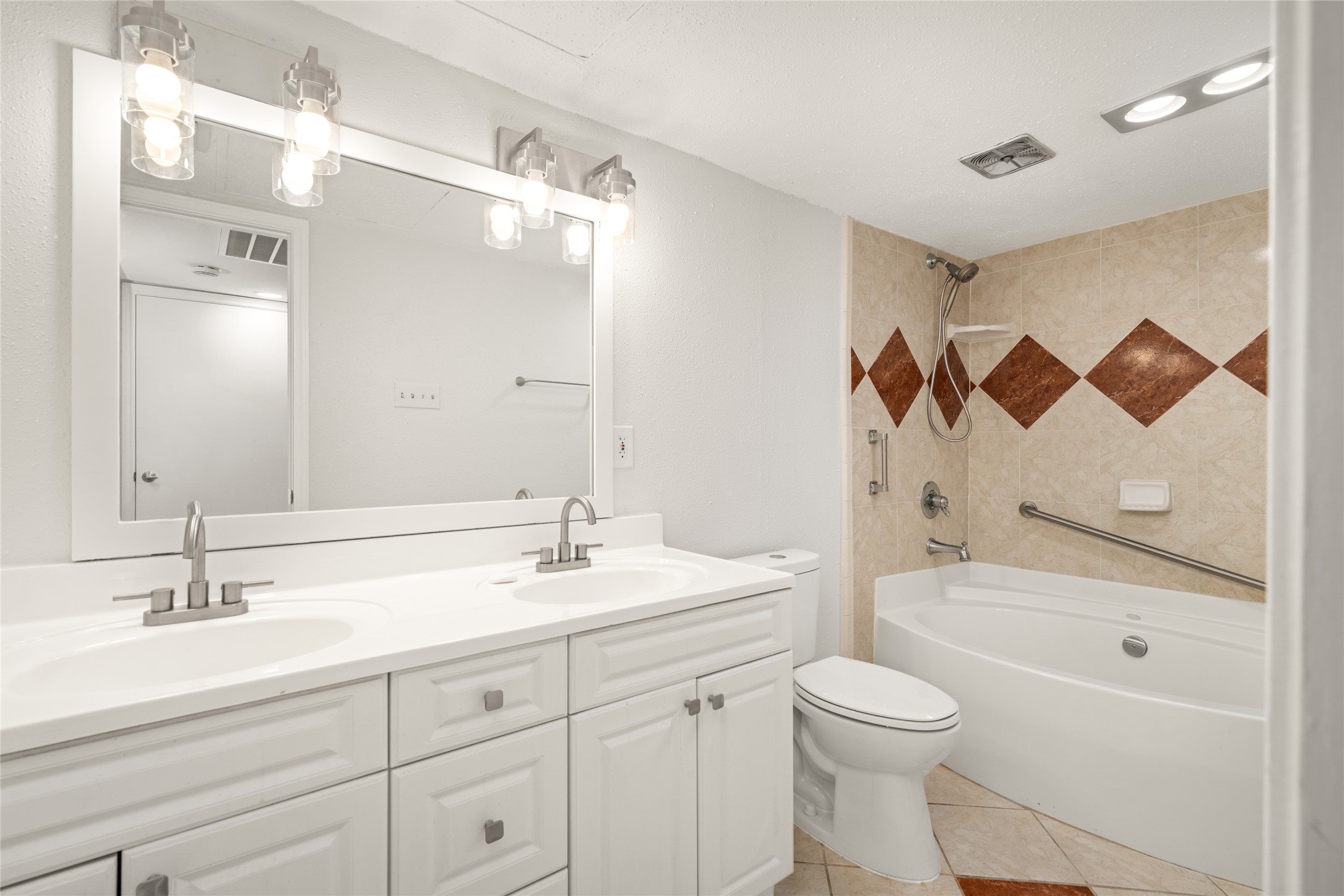 2238 South Piney Point Road, Unit 102 Houston, TX 77063 - Photo 26 of 34 Ensuite bath to BEDROOM 2. 2026 Moen shower faucet, 2026 Project Source toilet, 2026 Phiestina sink faucet. 2026 Kawoti lighting. Framed mirror. Double sinks.