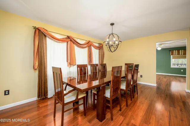 a view of a dining room with furniture a chandelier and wooden floor