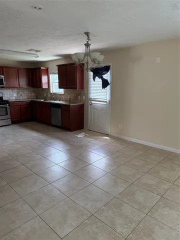 a kitchen with stainless steel appliances a sink a stove top oven a counter space and cabinets