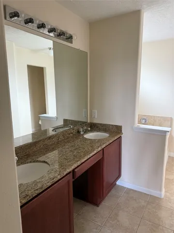 a bathroom with a granite countertop sink and a mirror