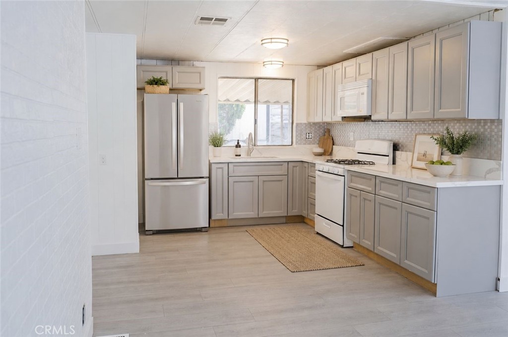 995 Pomona Road, Unit 33 Corona, CA 92882 - Photo 4 of 25 a kitchen with white cabinets stainless steel appliances and a window