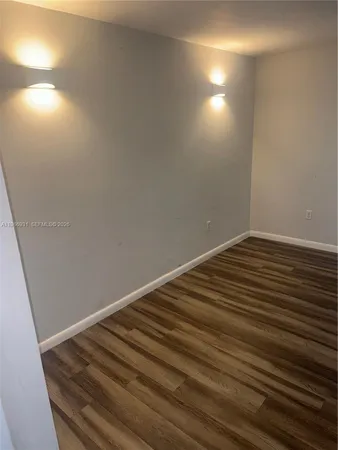a view of room with wooden floor and windows