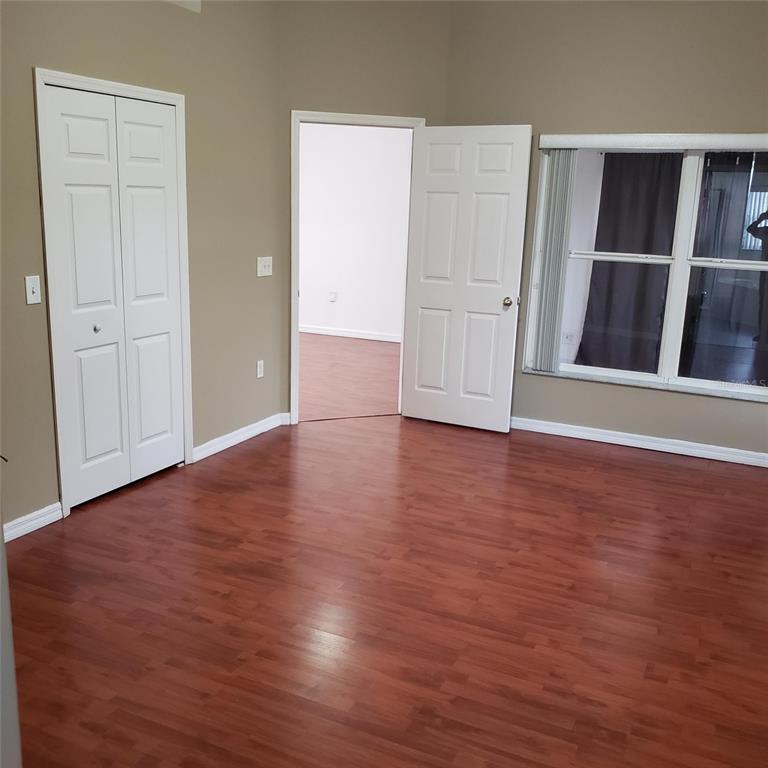14111 Colonial Spring Way Orlando, FL 32826 - Photo 18 of 26 an empty room with wooden floor and windows