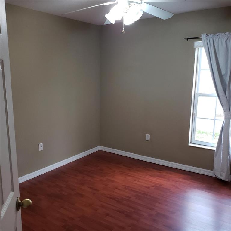 14111 Colonial Spring Way Orlando, FL 32826 - Photo 23 of 26 an empty room with wooden floor and windows