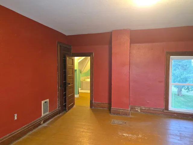 an empty room with wooden floor and glass doors