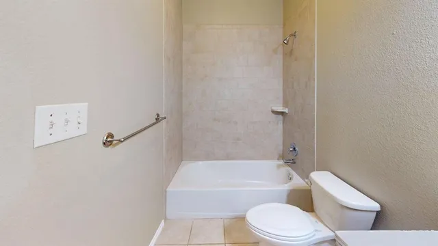 a white toilet and tub sitting next to a white cabinet