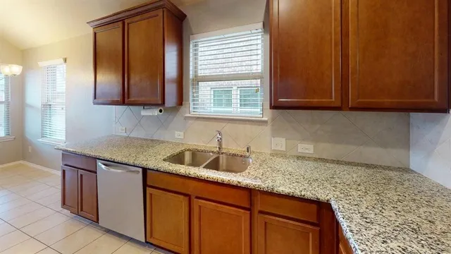 a kitchen with granite countertop cabinets sink and window