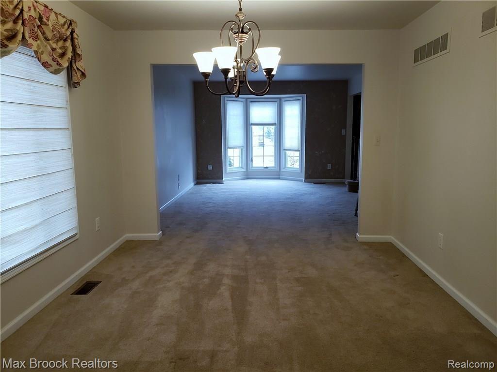 Formal Dining Room opens to Living Room with floor to ceiling bay window