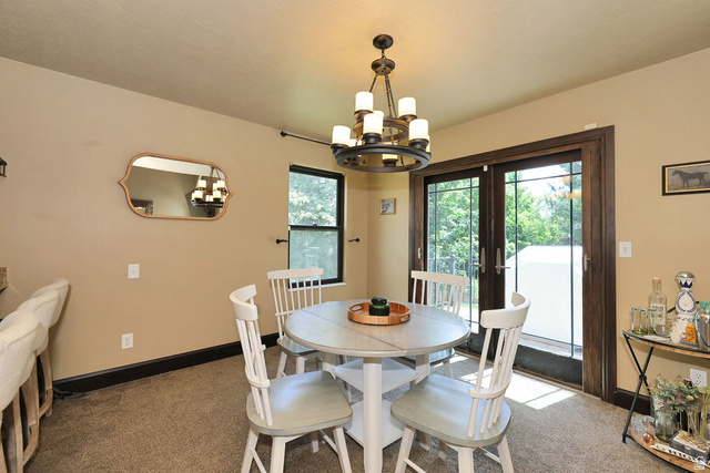 3104 East High Danish Road Sandy, UT 84093 - Photo 11 of 36 Dining area featuring an overhead chandelier, a built-in bar, and glass doors with exterior access