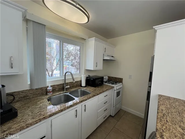 a kitchen with stainless steel appliances granite countertop a sink stove and cabinets