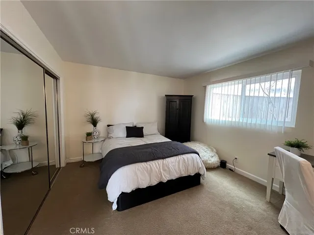 a spacious bedroom with a bed and a window