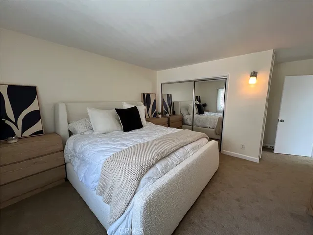 a large bed sitting in a bedroom and a mirror